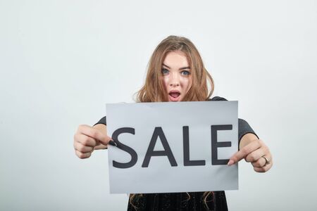 girl brown haired in black dress over isolated white background shows emotionsの写真素材