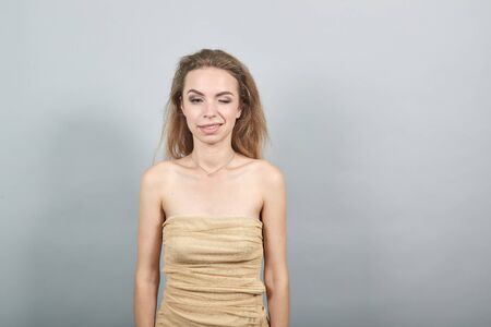 Beautiful girl in beige t-shirt over isolated white background shows emotions