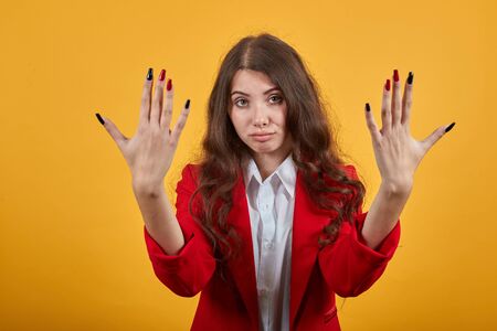 Unhappy caucasian young woman in fashion white shirt showing manicure at camera, disappointed...