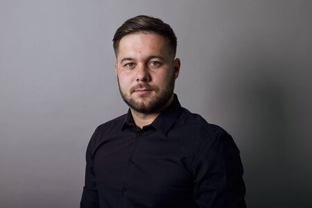 Young Bearded Dark Haired Man In Black Stylish Shirt On Gray Background, Portrait Of Confident,...