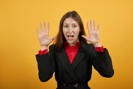 Young Attractive Woman Brunette In Black Stylish Suit, Red Shirt On Yellow Background, Puzzled Woman...