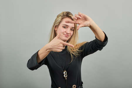 Hands making photo frame, fingers framing distance, photography sign made by human arm, framework formed, feeling happy, friendly and positive, smiling, portrait.の写真素材