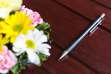 photo of flower  and pencil  on the tableの写真素材