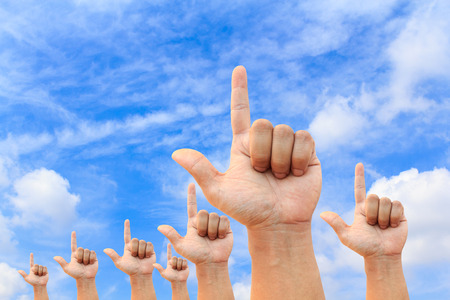 Photo of any hand  pointed into the clear blue skyの写真素材