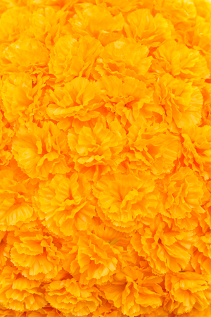 Photo of Artificial yellow Flowers lined with a background in verticalの写真素材