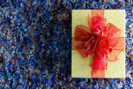 A gift box for someone special, tied with a ribbon, placed on the floor Ideas to welcome the...