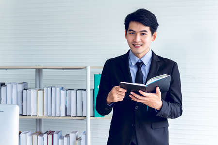 Portrait of young asian business  take action reading a book to find idea for business finance concept.の写真素材