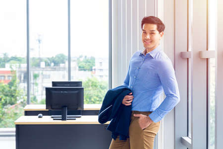 Handsome young businessman Asian caucasian wear a Long sleeve shirt and put the suit on his arm, be...