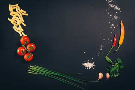 Food concept background. Black desk or chalkboard seen from above, top view. Copy space around...