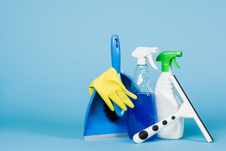 Cleaning concept - mixed detergents and cleaning accessories isolated on blue seamless background.の写真素材