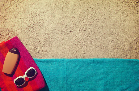Top view of sandy beach with summer accessories and copy space