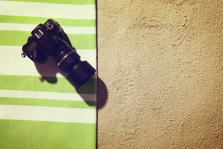 Top view of sandy beach with towel and digital SLRの写真素材