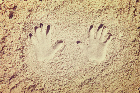Top view of sandy beach with hand shapes, handprintの写真素材