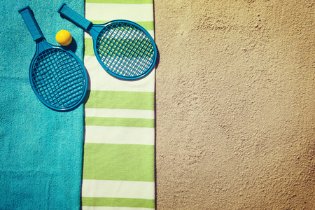 Top view of sandy beach with summer accessories and tennis rocketの写真素材