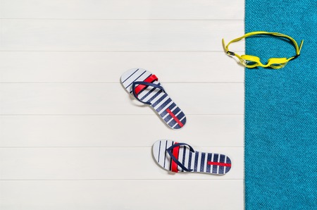 Top view of beach summer accessories with copy space. Lay flat holiday fashion background on white wooden table or floor. Horizontal frame for spa or wellness concept.の写真素材