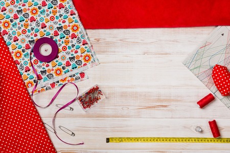 Background with sewing or knitting tools and accessories. Set for needlework placed on white wooden...