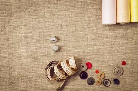 Background with sewing and knitting tools and accesories. Set for needlework placed on flax fabric. Image taken from above, top view. A lot of copyspace.の写真素材