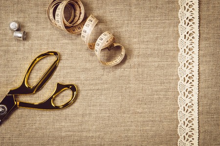 Background with sewing and knitting tools and accesories. Set for needlework placed on flax fabric....