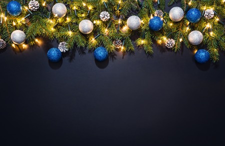 Christmas decoration background over black chalkboard, top view. Horizontal photo of decorations...