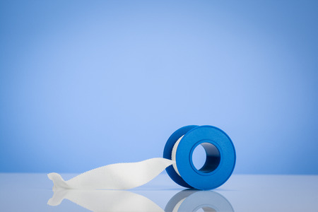 Medical concept background on a white, reflective desk surface. Low angle and blue backdrop. Concept image for use as a frame for advertising.の写真素材