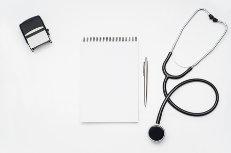 Top view of modern, sterile doctors office desk. Medical accessories on a white table background with copy space around products. Photo taken from above.の写真素材