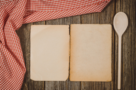 Vintage cookbook with cooking ingredients background. Top view photograph with kitchen utensils on vintage, natural, raw, wooden background with visible texture.の写真素材