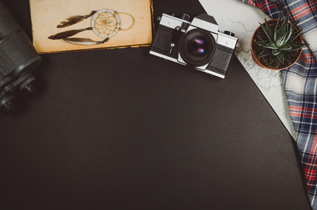 Accessories for travel top view on black chalkboard background with copy space. Adventure and wanderlust concept image with travel accessories. Preparing for an exotic trip, journey and sightseeing.の写真素材