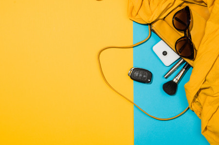 Womans accessories flat lay on colorful background. Top view Blue and yellow pastel colors with copy space around products. Horizontal image or photograph.の写真素材