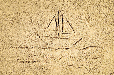 Top view of sandy beach with drawing in the sand or symbol. Background with copy space and visible sand texture.の写真素材