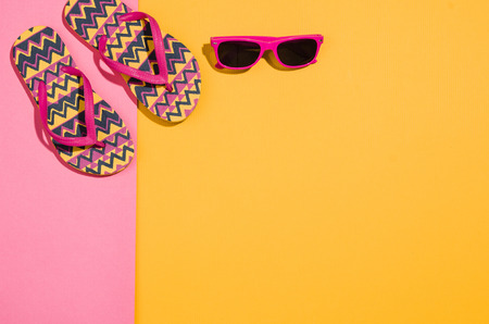Womans accessories flat lay on colorful background. Top view. Pink and yellow pastel colors with...