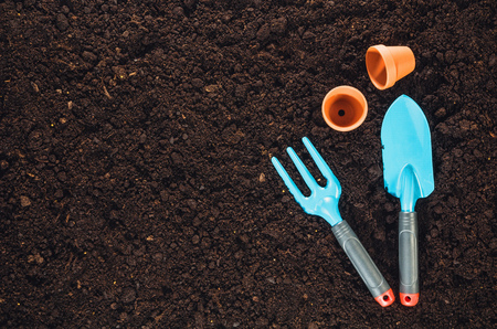 Gardening tools on fertile soil texture background seen from above, top view. Gardening or planting concept. Working in the spring garden.の写真素材