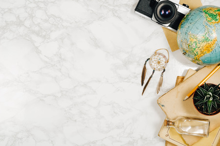 Accessories for travel top view on white natural marble background with copy space. Adventure and wanderlust concept image with accessories. Traveler preparing for an exotic trip and journey.の写真素材