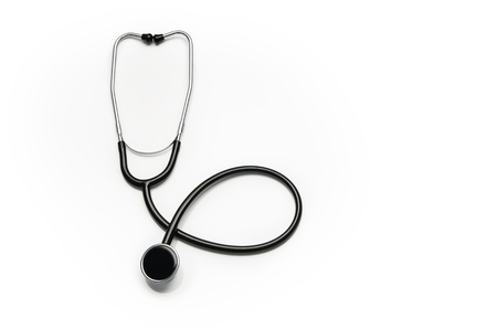Stethoscope isolated on white background. Sterile doctors office desk. Medical accessories on a white table background with copy space around products. Photo taken from above.の写真素材