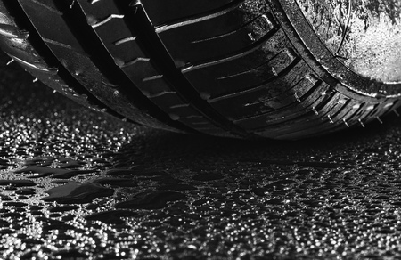 Studio shot of a set of summer, fuel efficient car tires on black background. Covered in wated droplets, rain or aquaplaning concept. Contrasty lighting and shallow depth of fieldの写真素材