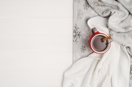 Mug with tea and home decor on white, cosy wooden table background. Winter morning relax concept, top view. Frame with cup and copy space around objects.の写真素材