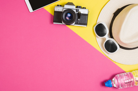 Woman's accessories lying flat on pink paper table background.の写真素材