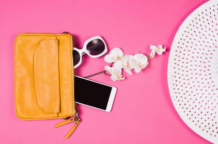 Womans accessories lying flat on pink paper table background. Pastel colors with copy space around products . Image taken from above, top view. Minimal style with room for textの写真素材