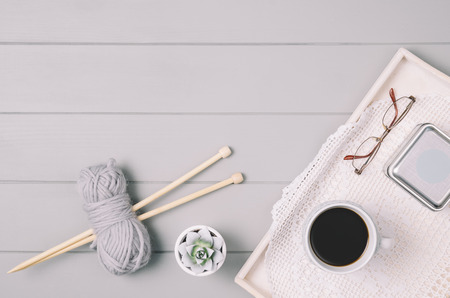 Knitting accessories assortment background with wool and needles on gray wooden table. Photograph...