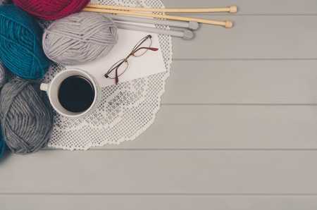 Knitting accessories assortment background with wool and needles on gray wooden table. Photograph taken from above top view. Frame composition with copy space around products.の写真素材