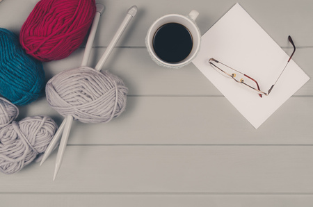 Knitting accessories assortment background with wool and needles on gray wooden table. Photograph taken from above top view. Frame composition with copy space around products.の写真素材