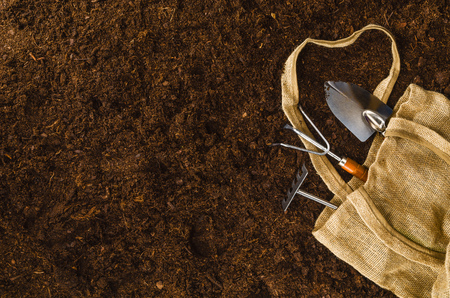 Gardening tools on fertile soil texture background seen from above, top view. Gardening or planting concept. Working in the spring garden.の写真素材