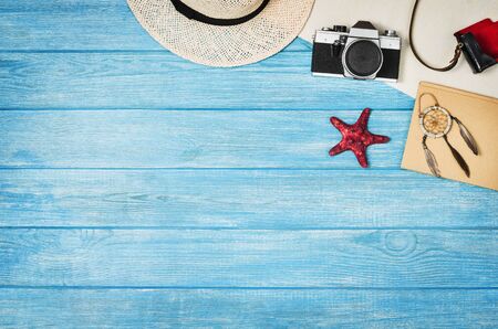 Accessories for travel top view on blue wooden background with copy space. Adventure and wanderlust concept image with travel accessories. Preparing for an exotic trip, journey and sightseeing.の写真素材