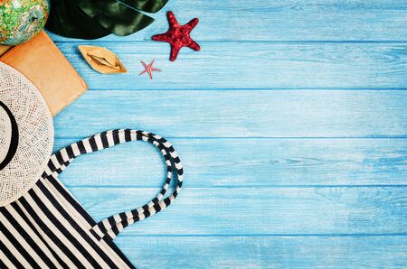 Accessories for travel top view on blue wooden background with copy space. Adventure and wanderlust concept image with travel accessories. Preparing for an exotic trip, journey and sightseeing.の写真素材