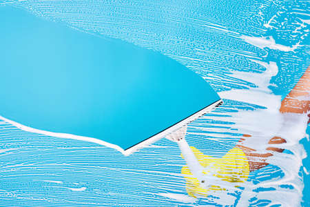 Cleaning conept - hand cleaning glass window pane with detergent