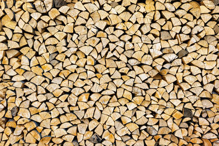 Stacked chopped wood close-up texture. Firewood storage background.の写真素材