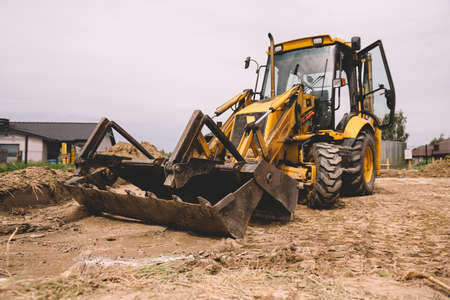 Excavator at house construction site - digging foundations for modern house