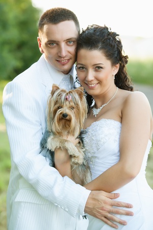 Bride and Groom similing with a dog の写真素材