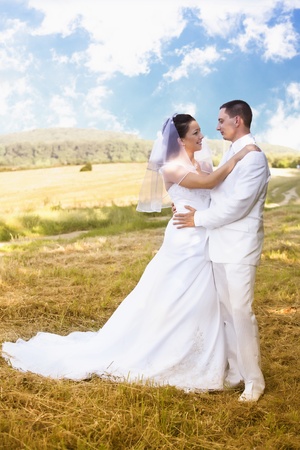 Bride and Groom standing in pretty landscapeの写真素材