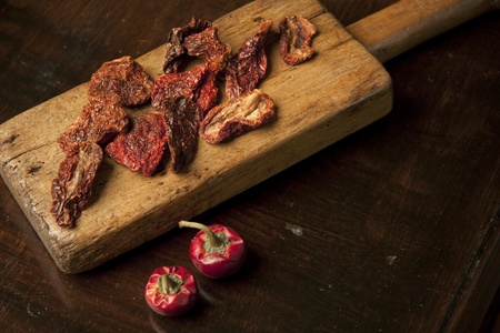 sun-dried tomatoes on wood cutting boardの写真素材