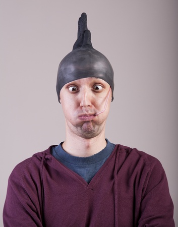 Funny man with a rubber glove on his headの写真素材